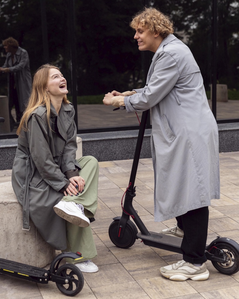 smiley couple conversing outdoors with electric scooters