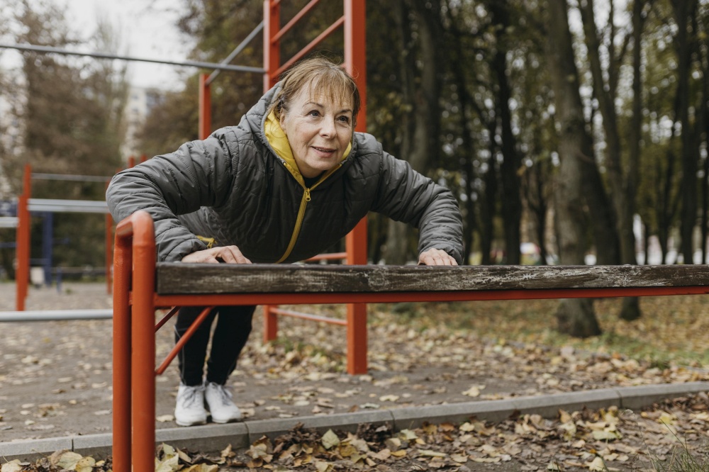 smiley elder woman doing push ups outdoors