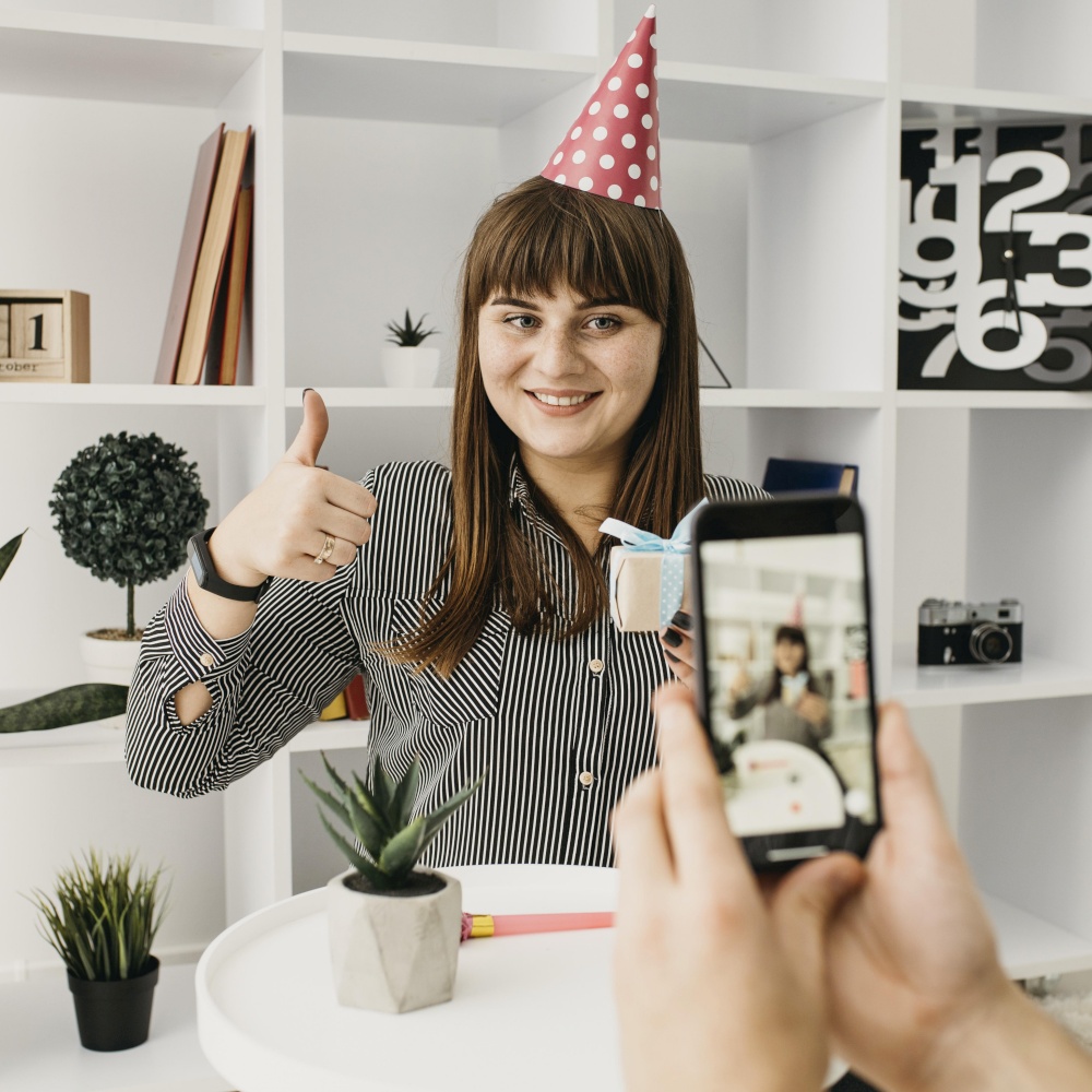 smiley female blogger streaming birthday with smartphone