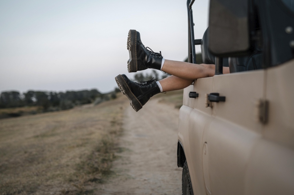 woman hanging her feet car while traveling