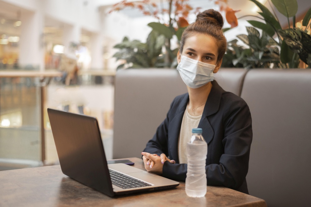 woman with medical mask working her laptop