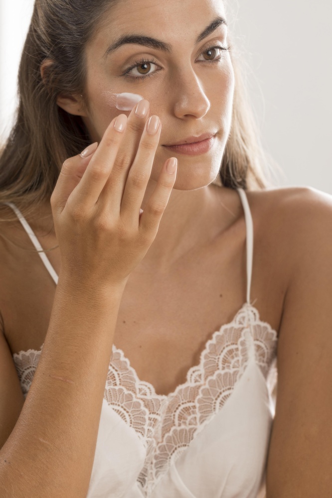 portrait woman applying cream her face