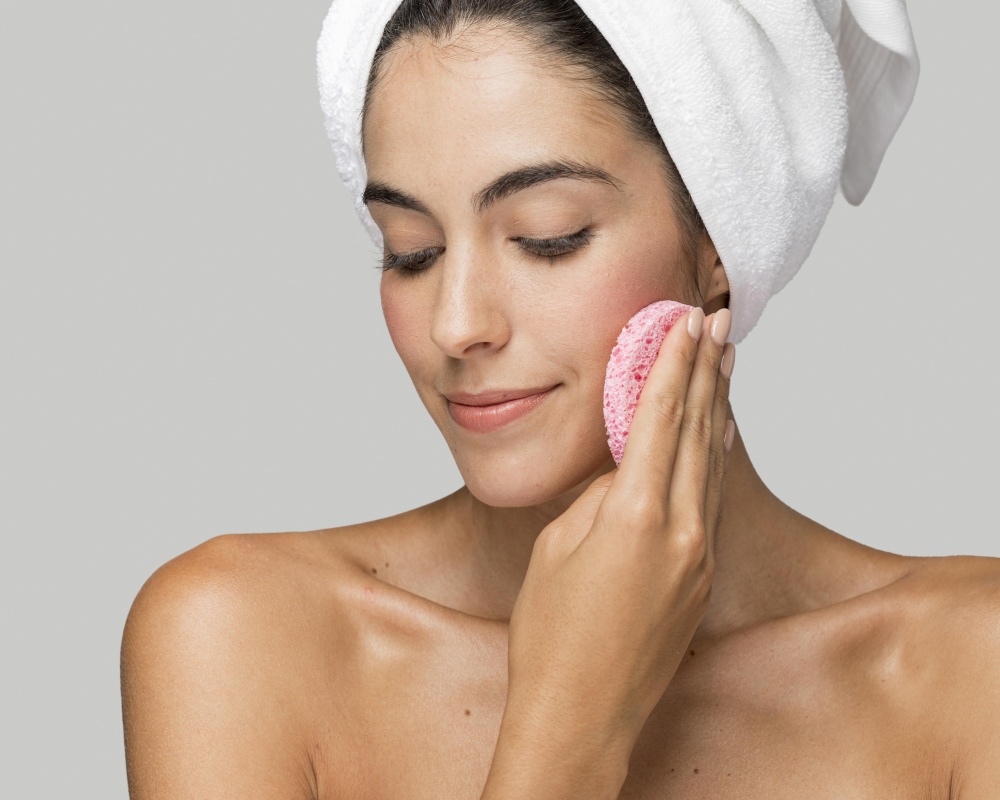 woman using pink sponge her face