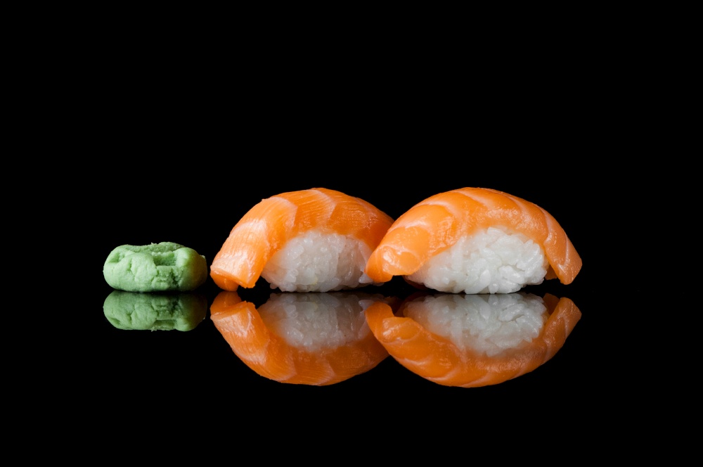 sushi with rice and wasabi on a black background with reflection. sushi on black background