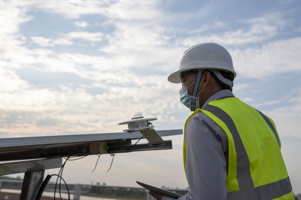 Engineer inspects pyranometer installation in solar farm to measure sunlight in solar power generation