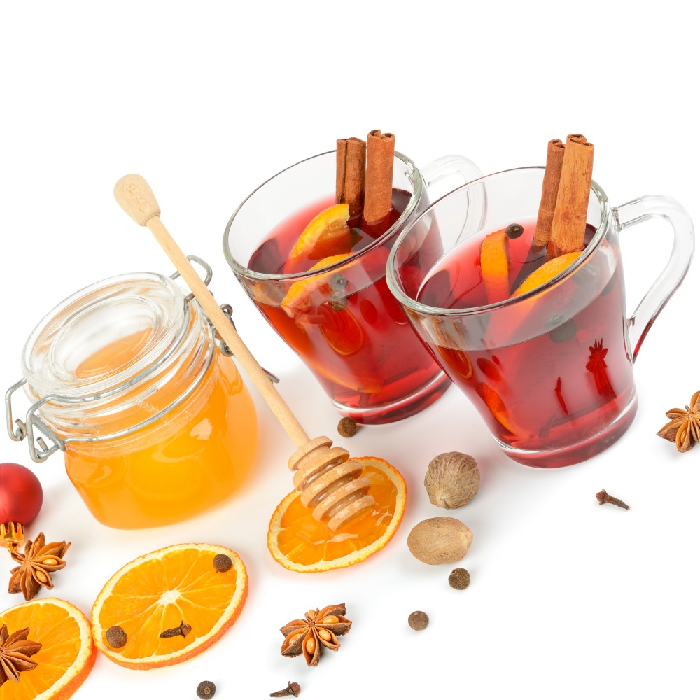 Mulled wine, honey, fruit orange and spices isolated on white background.