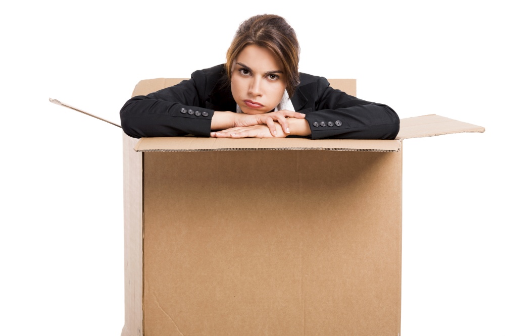 Stressed business woman appear inside a big card box, isolated over white background