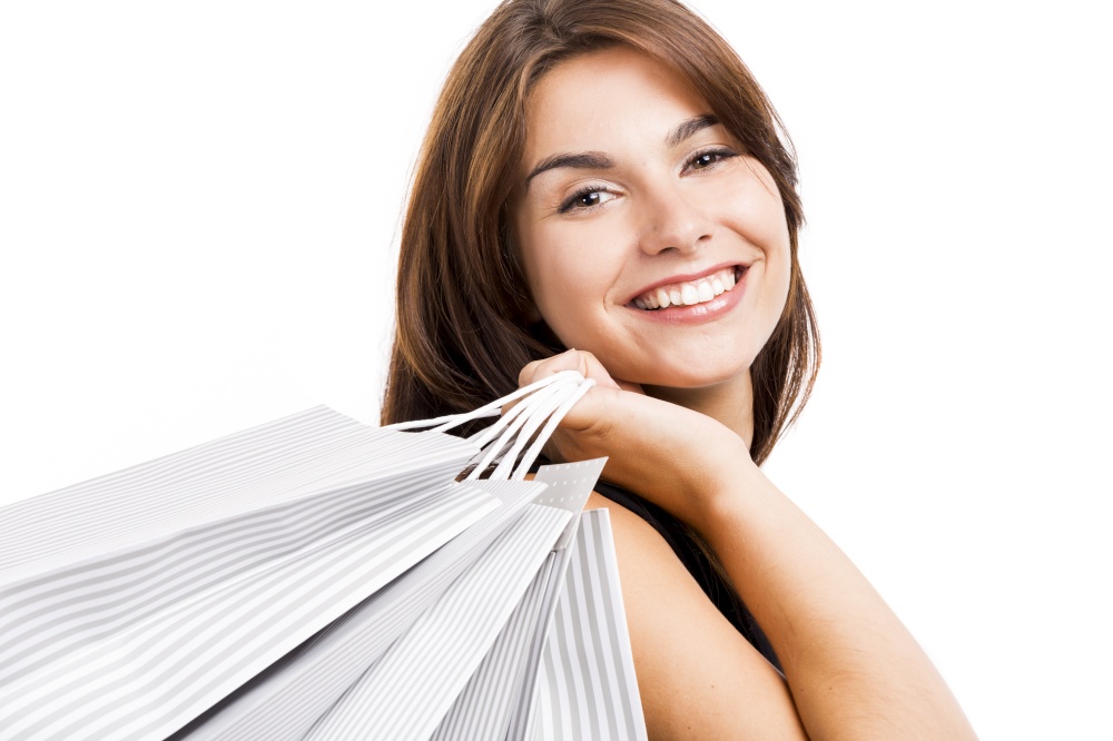 Happy and beautiful young woman posing with shopping bags, isolated over white background
