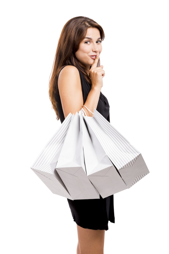 Attractive young woman shopping with a naugthy face, isolated over white background