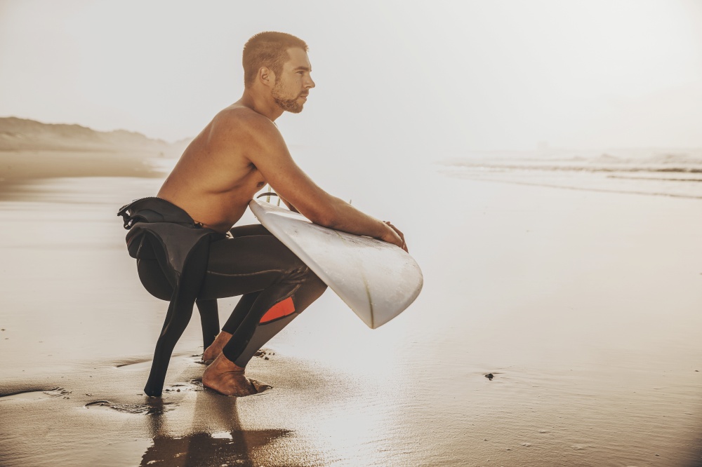 A surfer with his surfboard at the beach