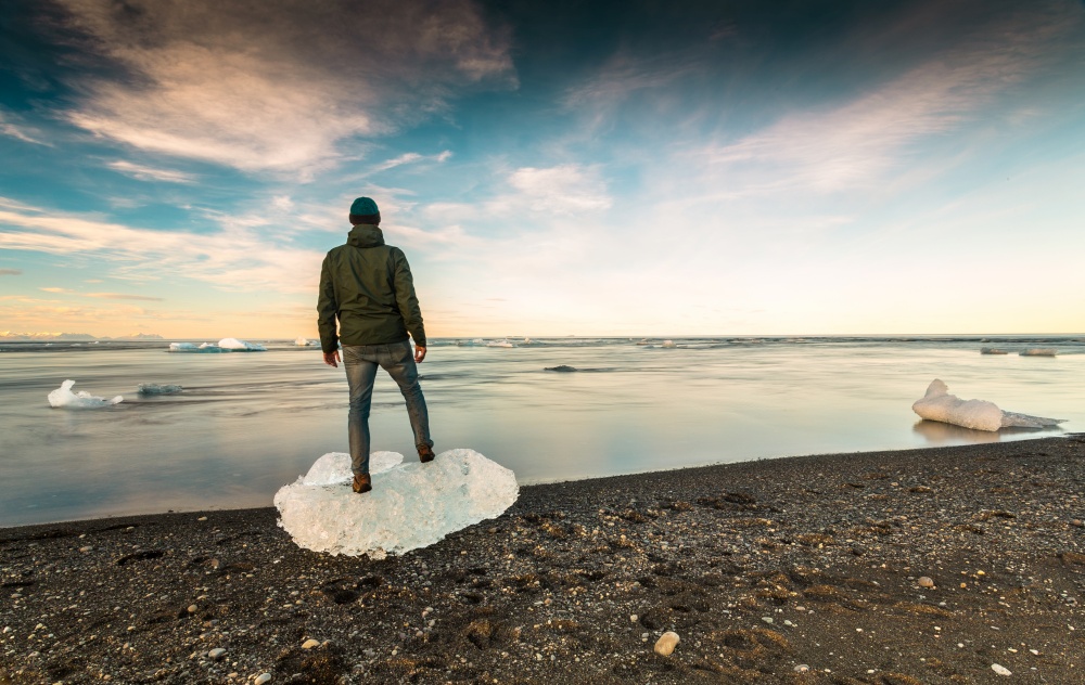 Man standing over Ice in Jokulsarlon, Iceland