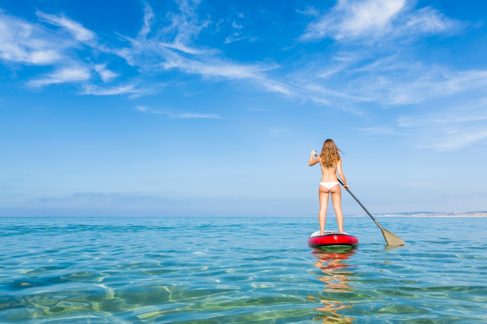 A beautiful woman practicing paddle on a beautiful sunny day