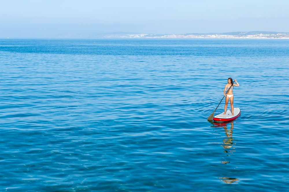 A beautiful woman practicing paddle on a beautiful sunny day