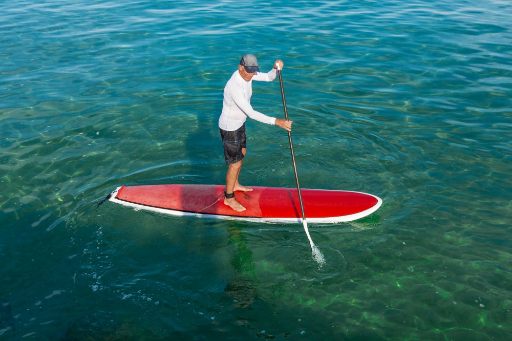 A senior man practicing paddle on a beautiful sunny day