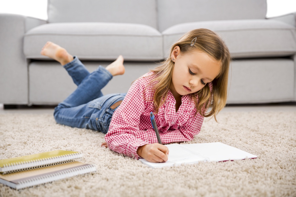 Cute little girl at home studying