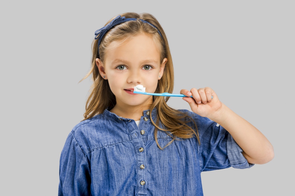 Happy little girl brushing her teeth