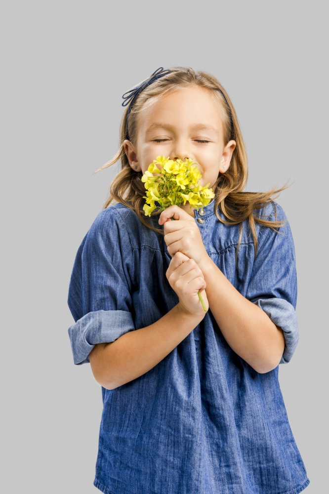 Studio portrait of a beautiful cute girl holding wild flowers