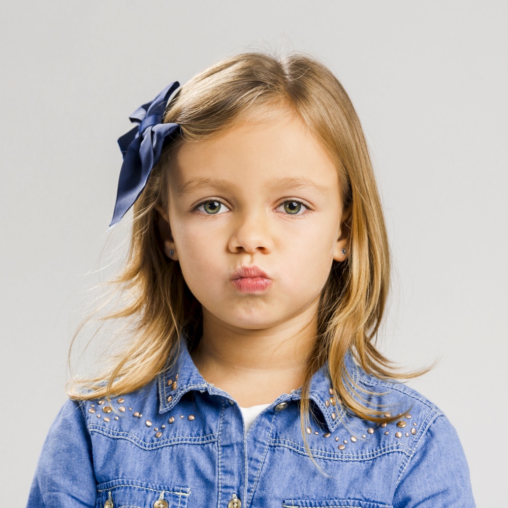 Portrait of a cute little girl with a annoyed expression