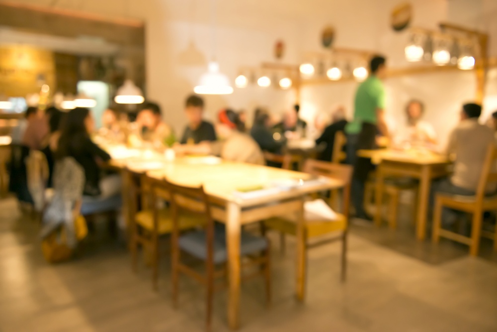 Blurred image of friends lunching and having fun at the restaurant