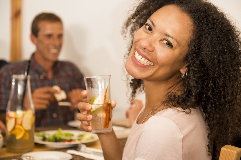 Happy Afro-American woman at the restaurant having a drink