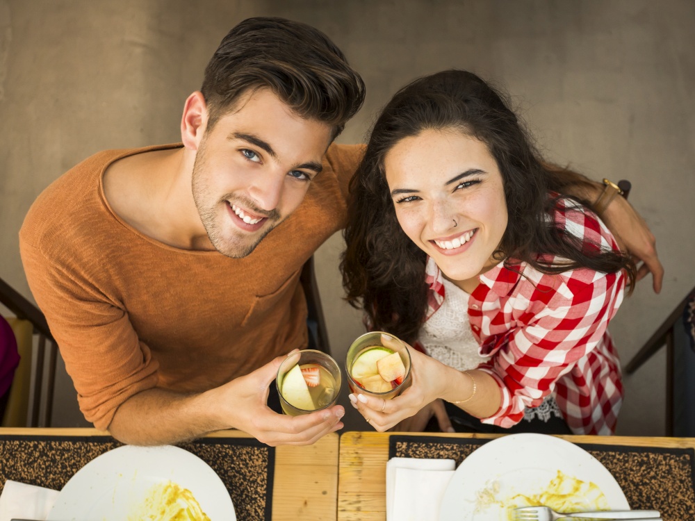 Young couple toasting and looking happy at a restaurant