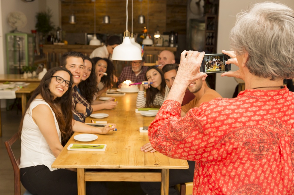 Granny taking a picture of all family celebrating the birthday grandfather