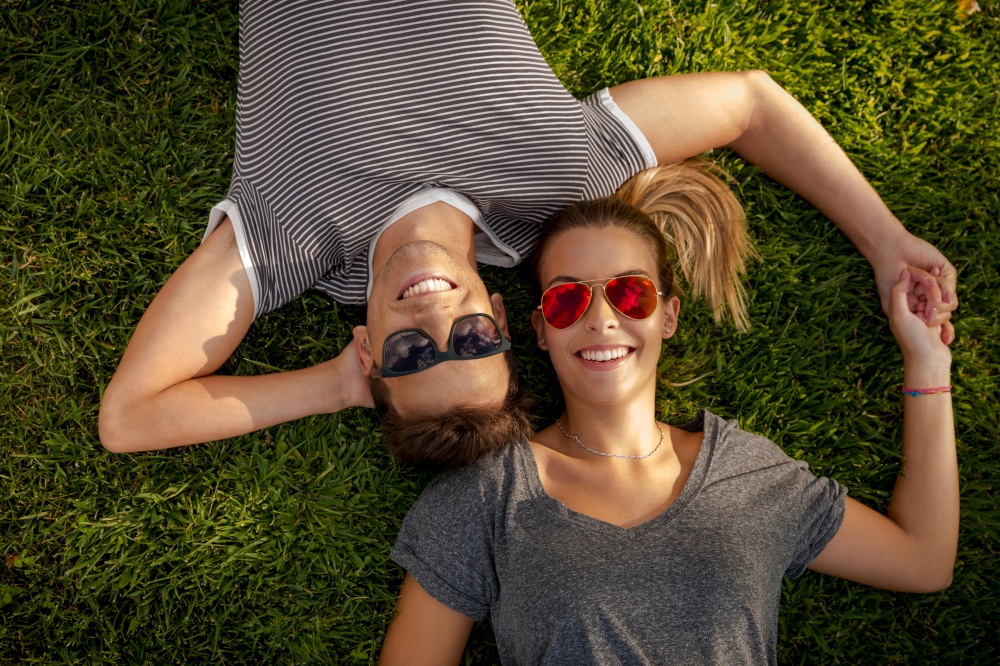 Portrait of a young beautiful couple lying on the grass