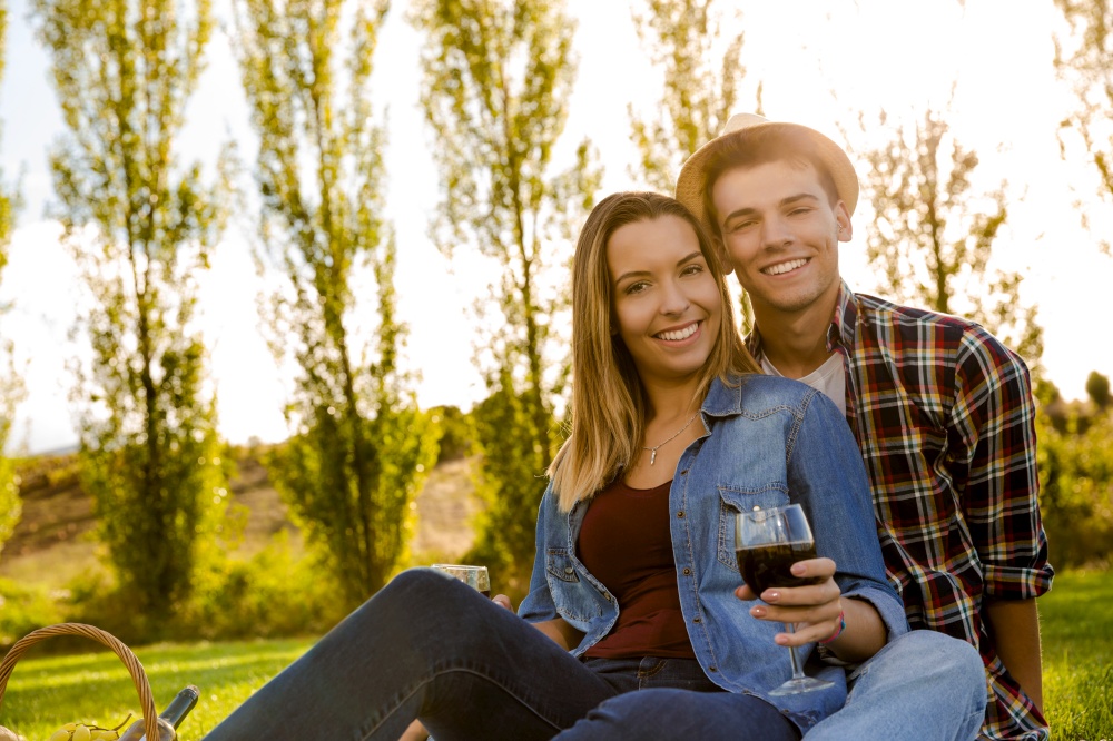 Portrait of a happy couple enjoying a day in the park together and drinking wine