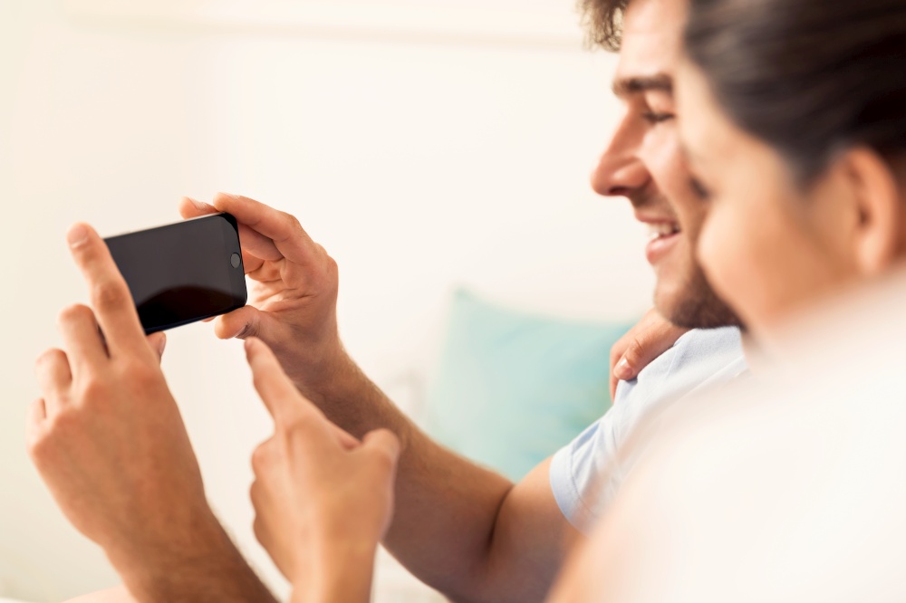 Young couple on bed watching videos on a cellphone