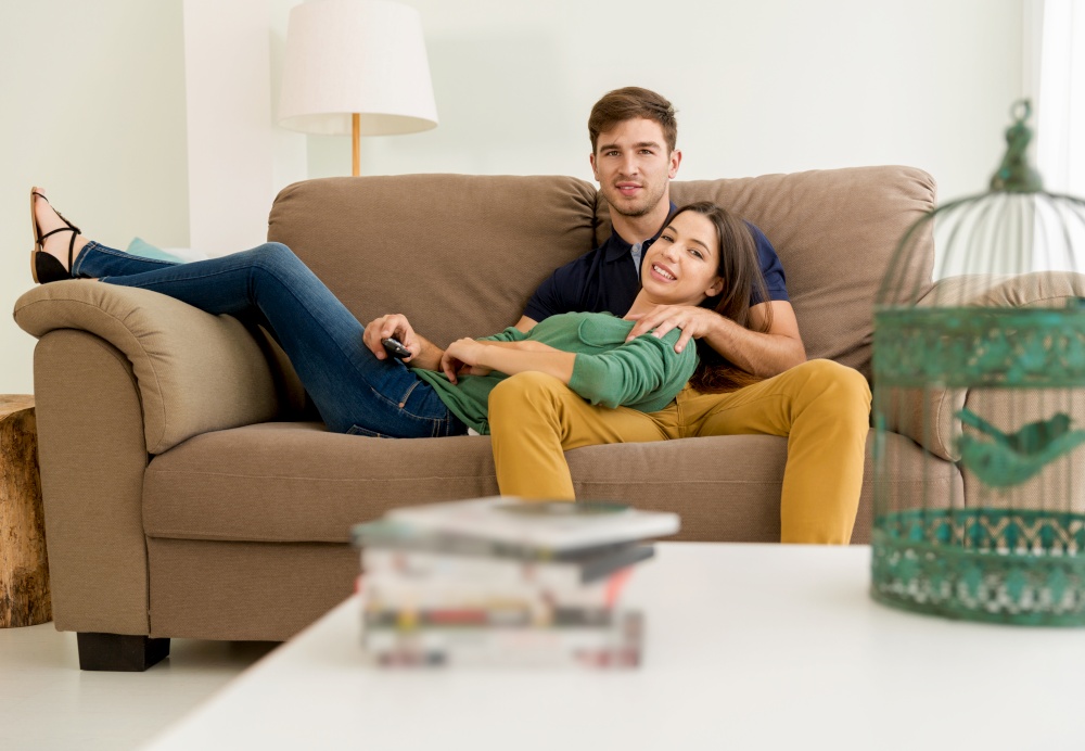 Young couple sitting on the sofa and watching movies