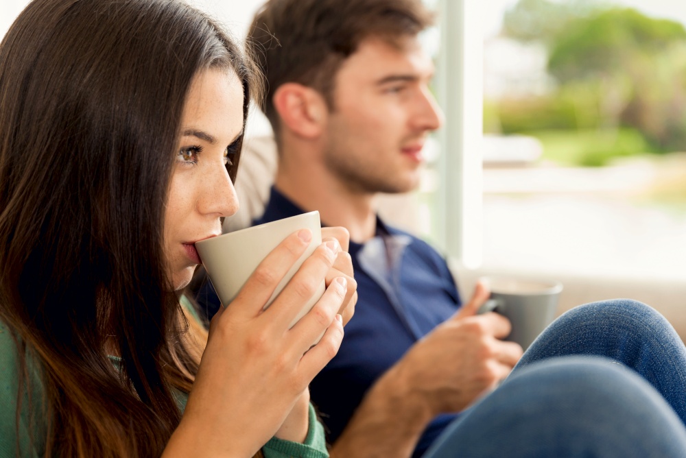 Young couple on the sofa drinking coffee