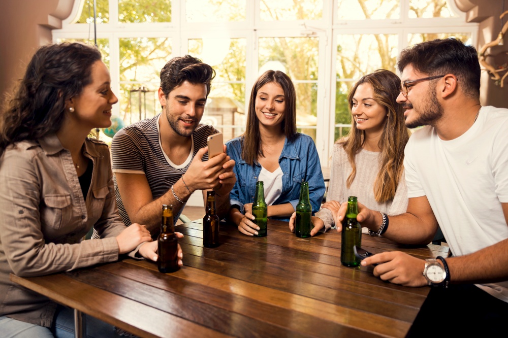 A group of friends at the bar drinking a beer