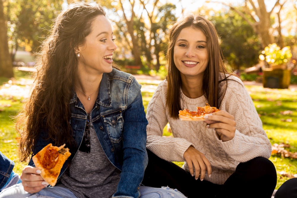 Friends at the park eating pizza