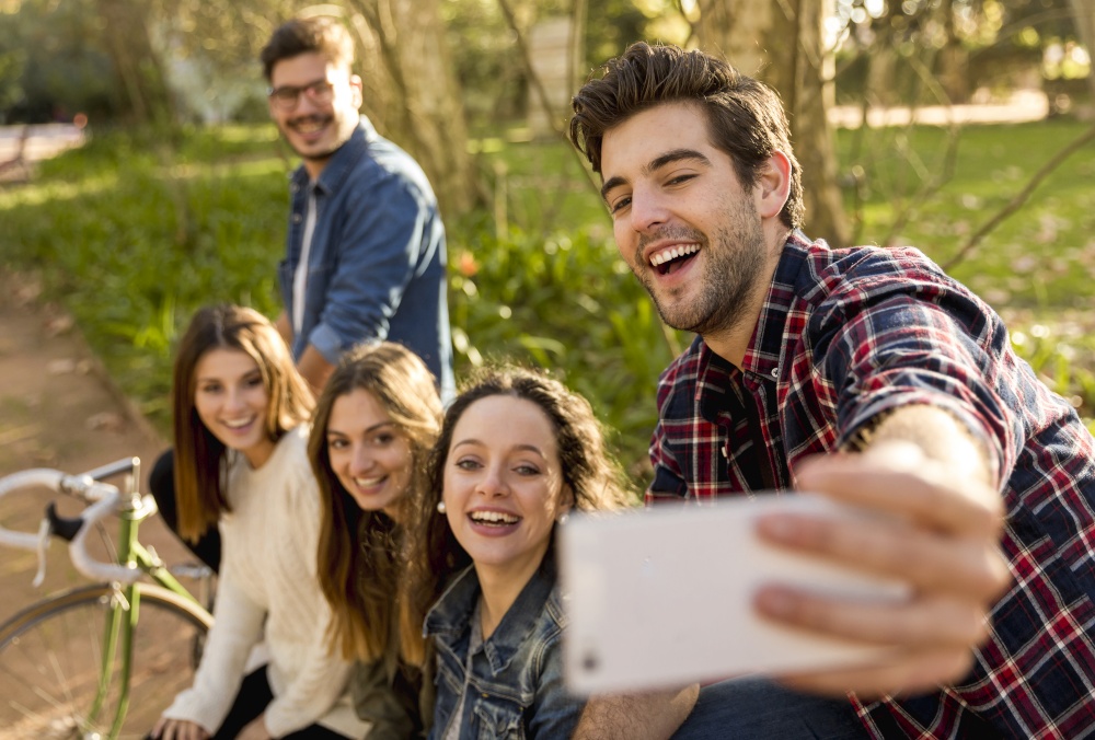 Group of students in the park having fun together makign a selfie