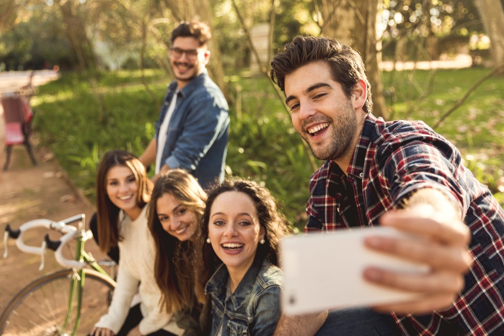 Group of students in the park having fun together makign a selfie