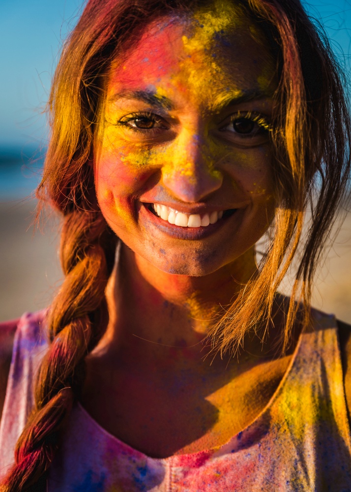 Portrait of a beautiful girl full of colored powder on the face