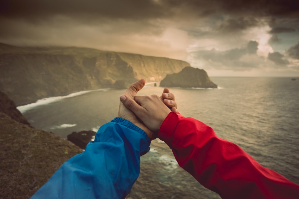 Couple giving hands with a beautiful landscape as background