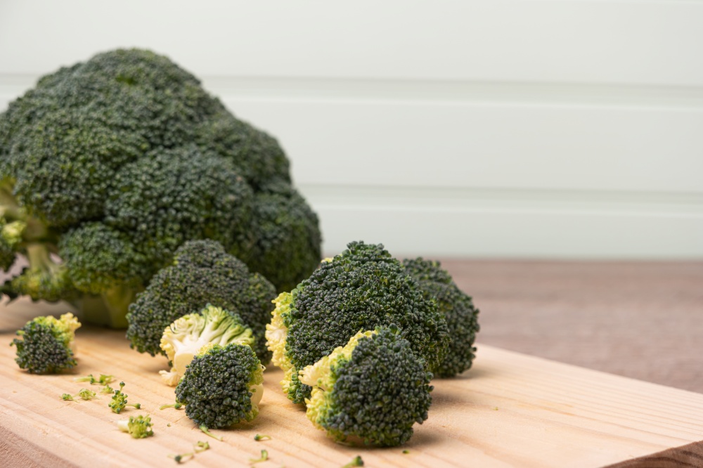 Fresh broccoli on wooden table close up.