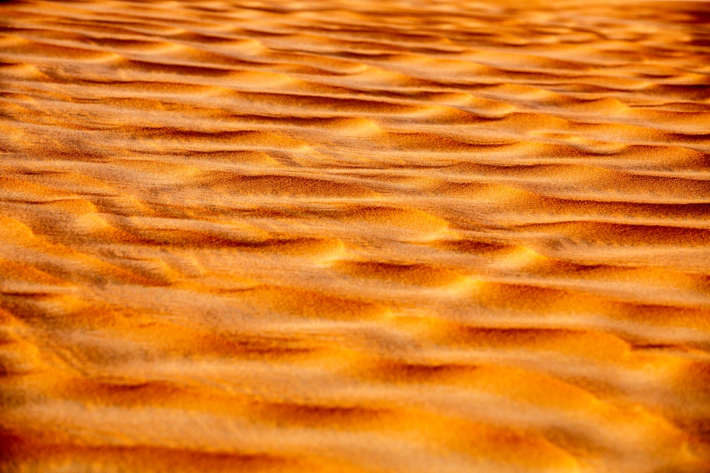 Beautiful sand background, seamless ripple orange sandy texture, abstract natural wallpaper, hot weather in the desert of Dubai