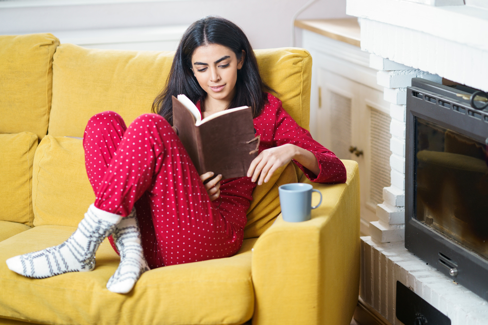Persian woman at home having tea and reading. Woman at home having tea and reading