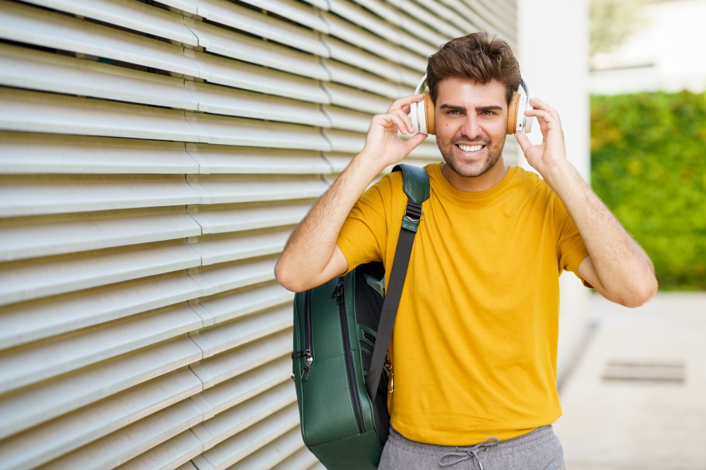 Portrait of young man with headphones in urban background. Young man with headphones in urban background