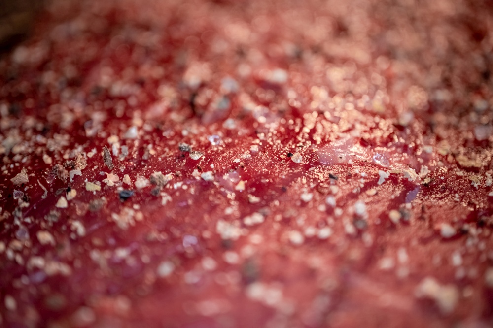 Mixed pepper and spices on the raw meat steak close up