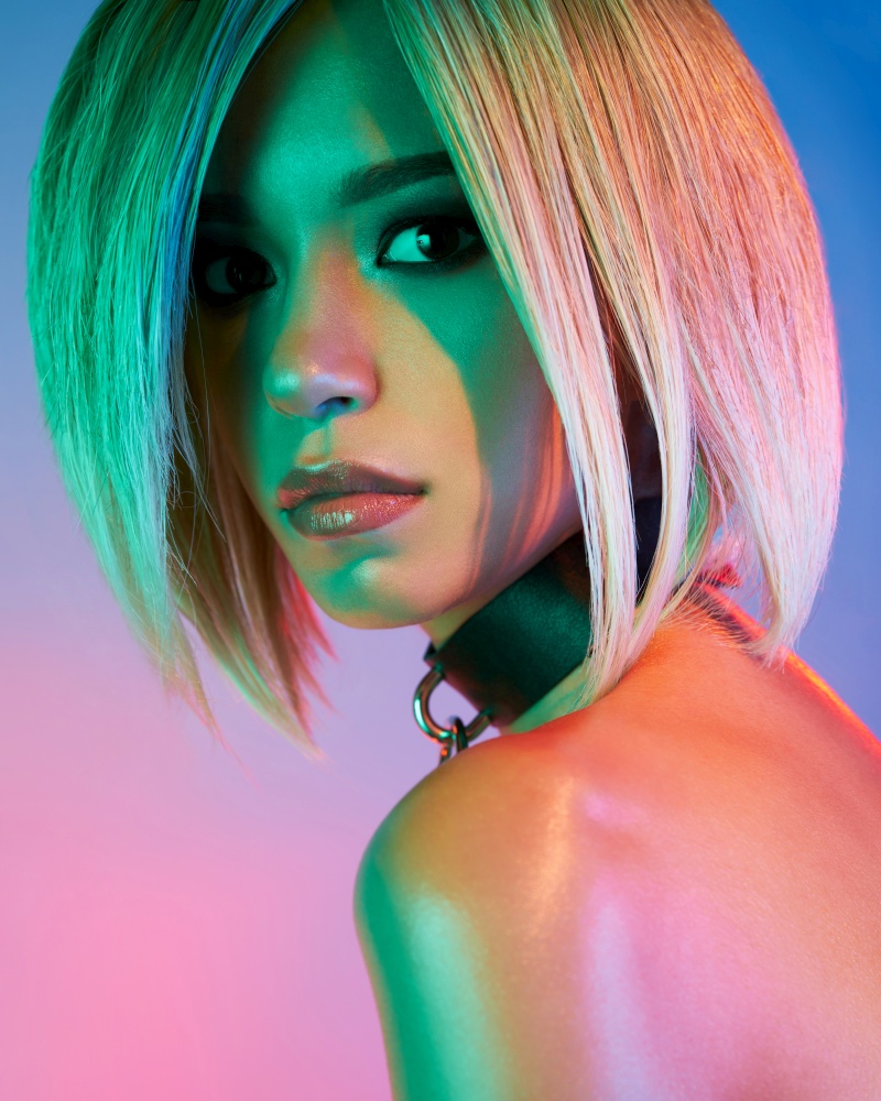 Fashion studio portrait of lovely asian woman with blonde short hair. Bright makeup. Fashionable haircut. Sexy young model in night club