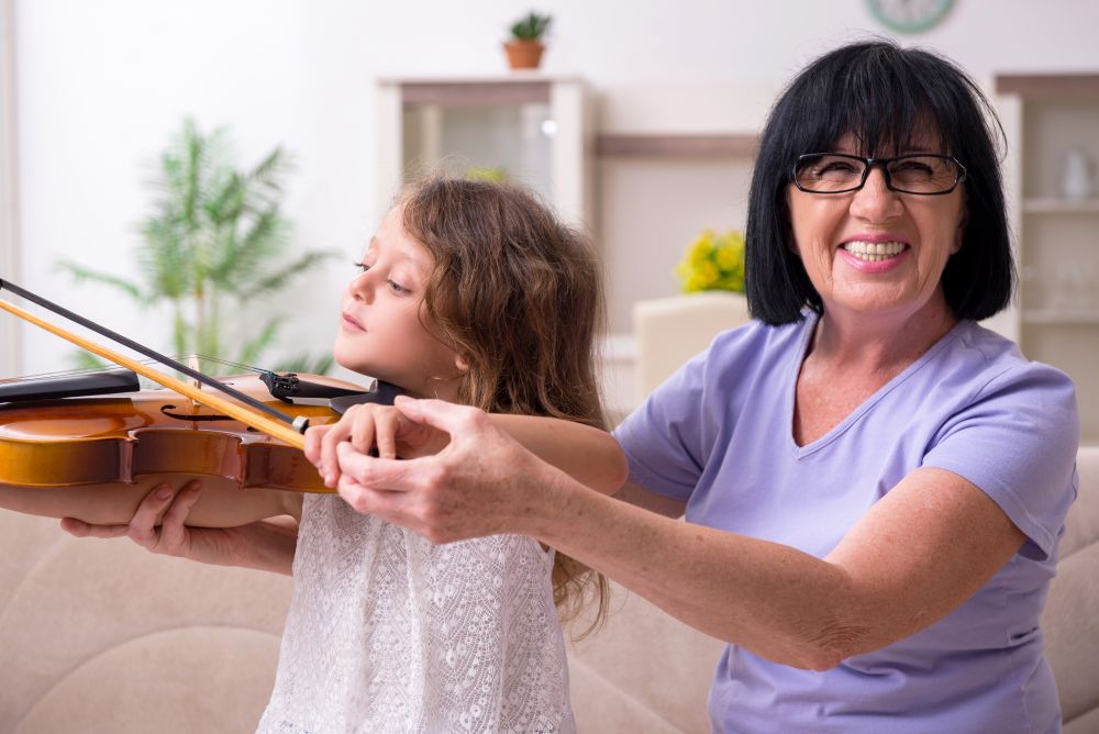 The old lady teaching little girl to play violin. Old lady teaching little girl to play violin