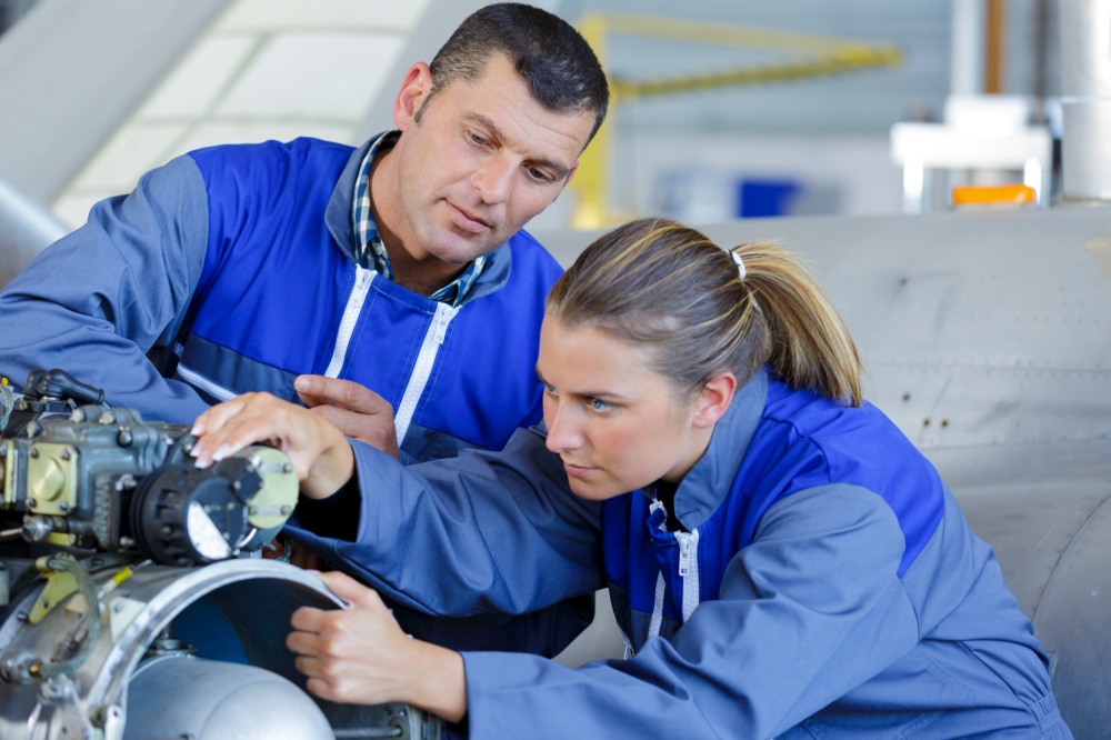 mechanic and assistant working at workshop