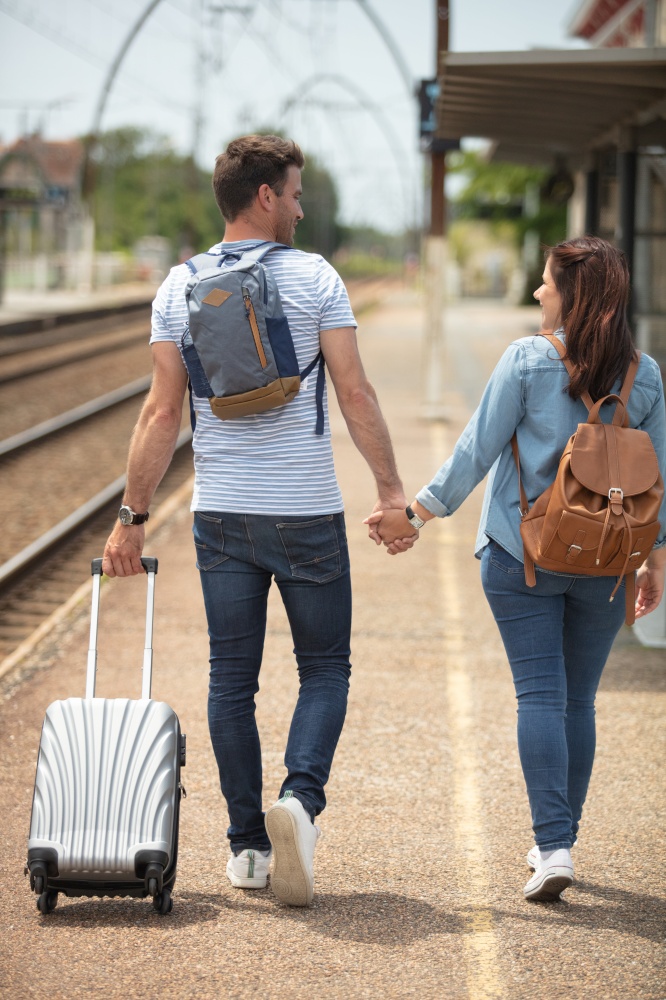 young man and woman walking along the railway platform
