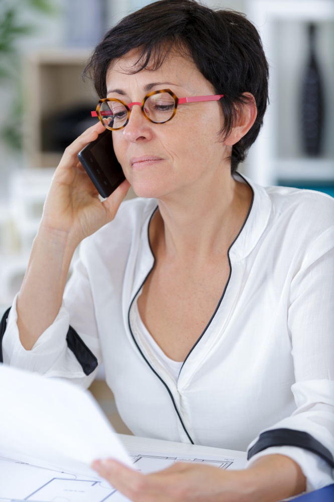 smiling woman wearing using a mobile phone in office
