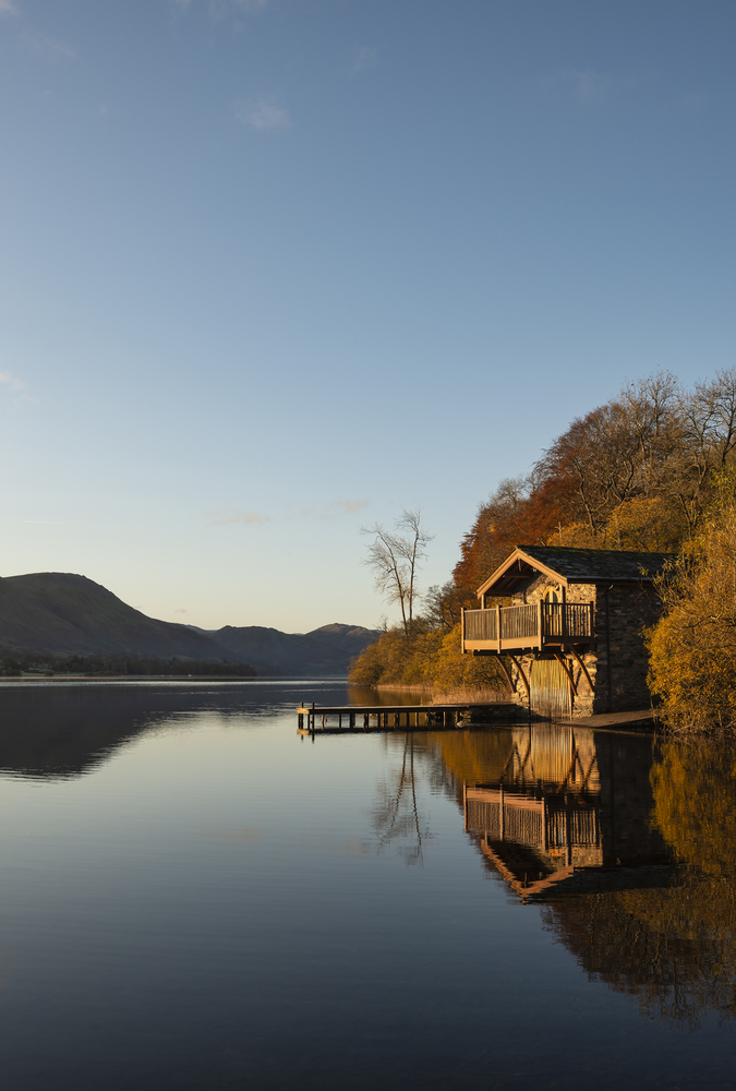 Stunning sunrise Autumn Fall landscape image of Ullswater in Lake District with golden sunlight