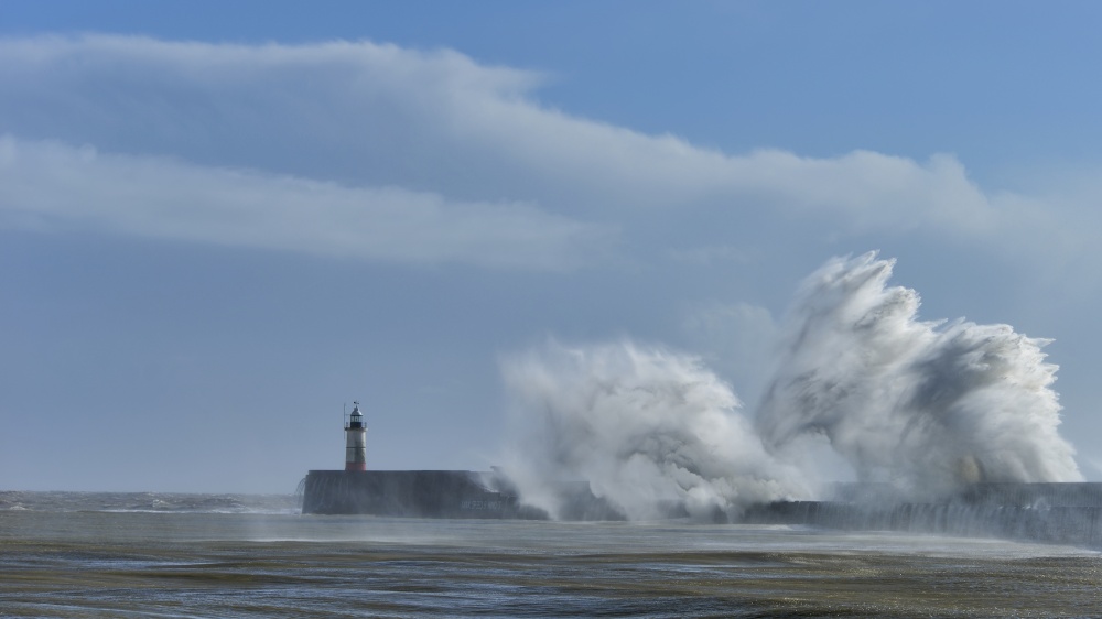 Huge waves crash over harbour wall onto lighthouse during huge storm on English coastline in Newhaven, amazing images showing power of the ocean