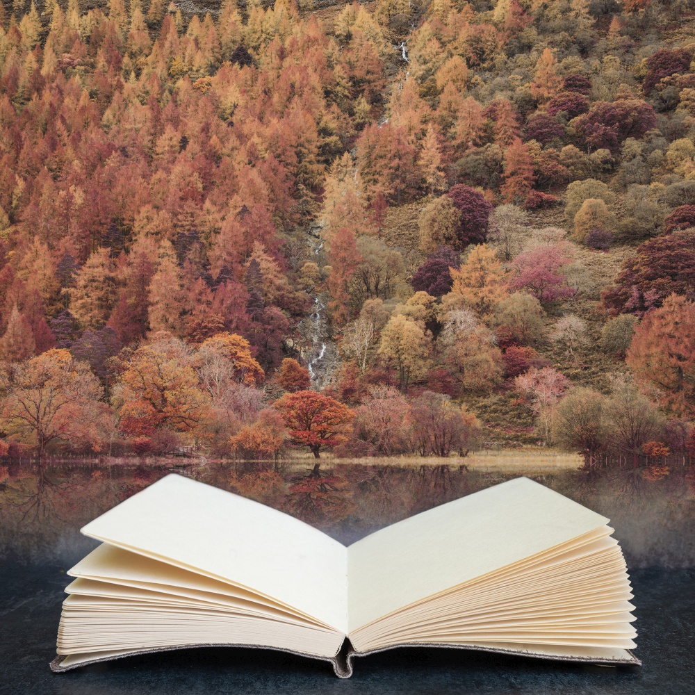 Stunning Autumn Fall landscape image of Lake Buttermere in Lake District England in pages of open fantasy book